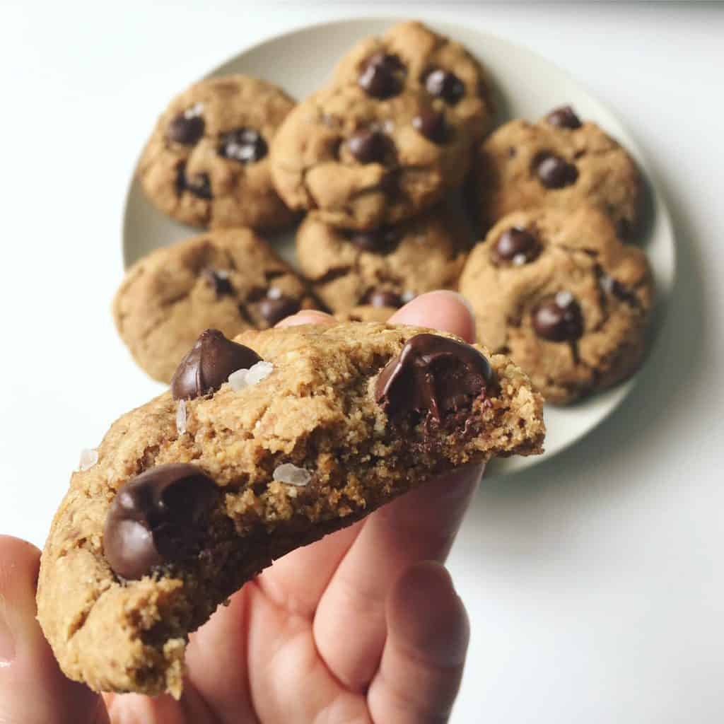 Flourless and gluten free chocolate chip cookie close up bite, sprinkled with sea salt. 