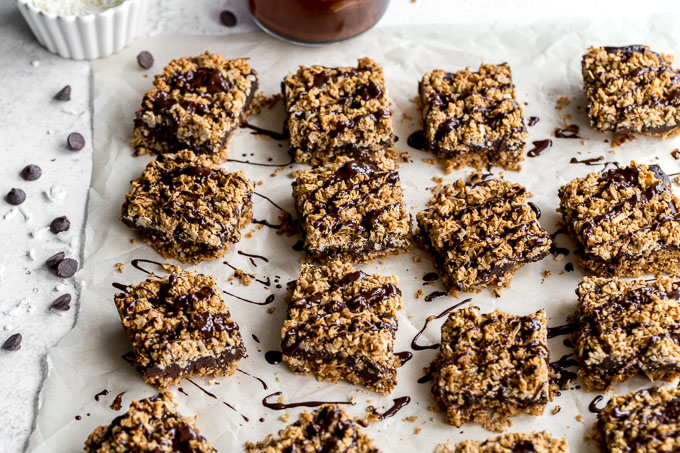 Chai spice bars drizzled with chocolate and arranged on a light coloured surface.