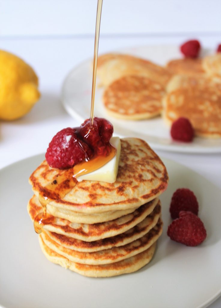 Healthy Lemon Ricotta Pancakes made with oat flour, naturally gluten free and refined sugar free. Topped with some raspberries and butter!