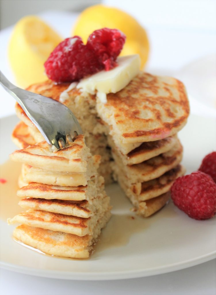 Healthy Lemon Ricotta Pancakes made with oat flour, naturally gluten free and refined sugar free. Topped with some raspberries and butter!