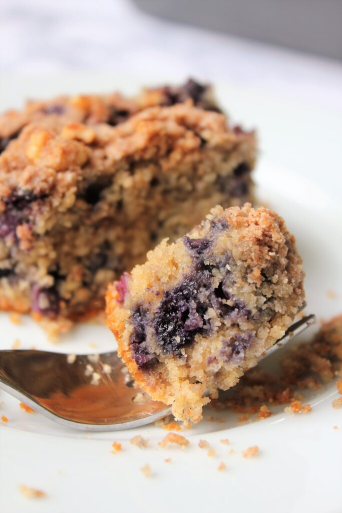 close up bite shot of a slice of healthy blueberry coffee cake