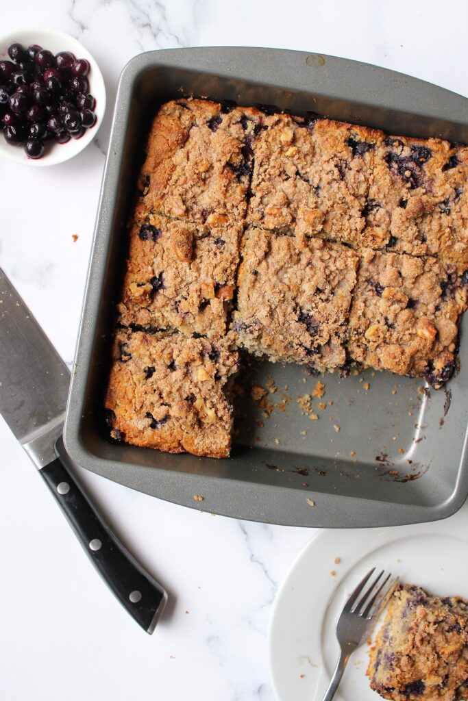 Overhead shot of blueberry buckle, cut into slices with a couple missing