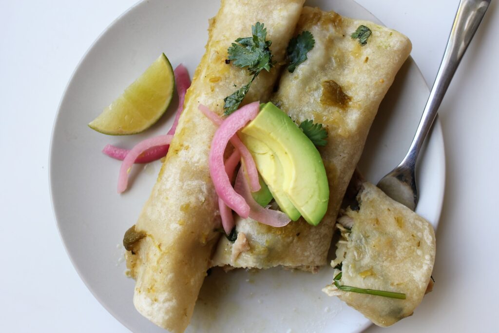 enchilads with avocado and pickled onion on top