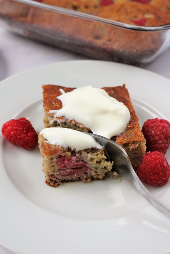 a slice of gluten free raspberry cake topped with more yogurt