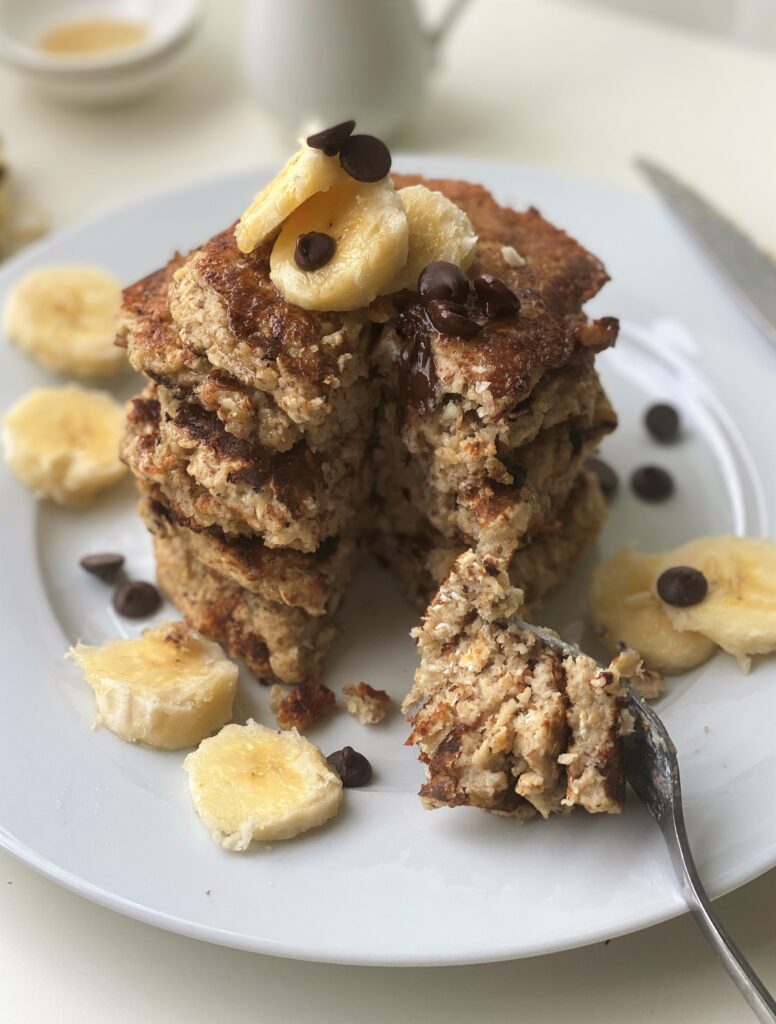 Stack of vegan oatmeal pancakes with a cut down all of them to show the inside texture