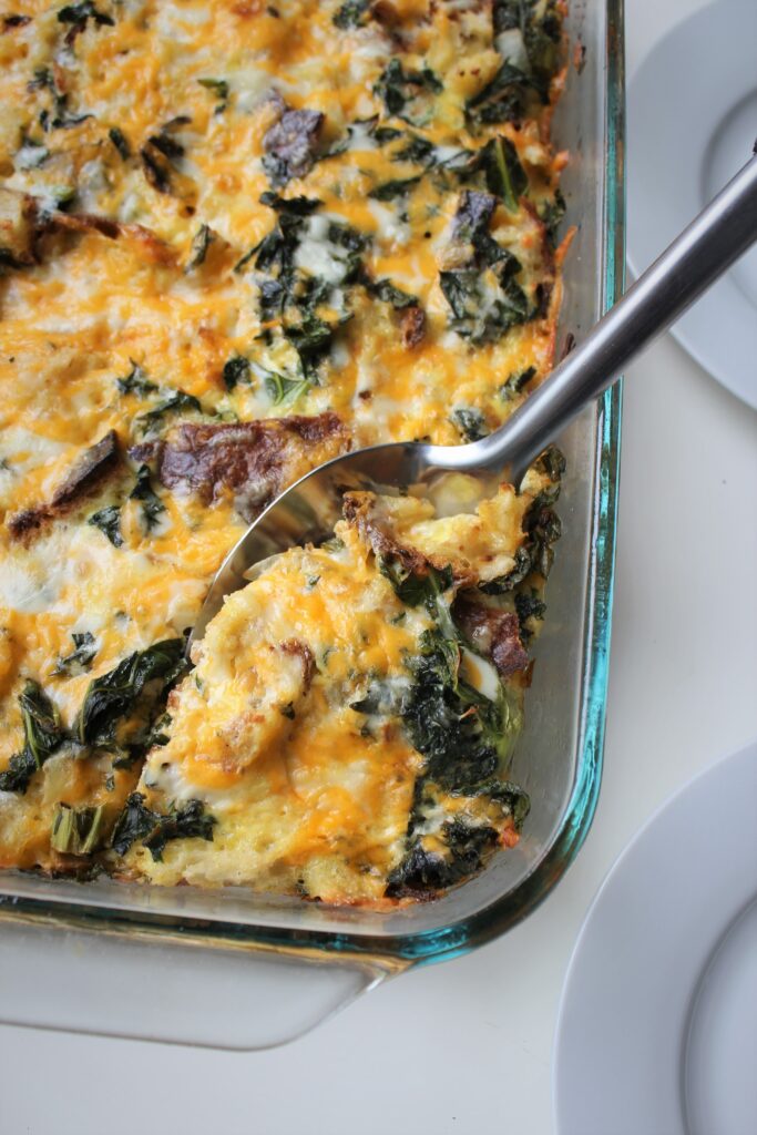 serving spoon serving the first portion of cheesy kale strata