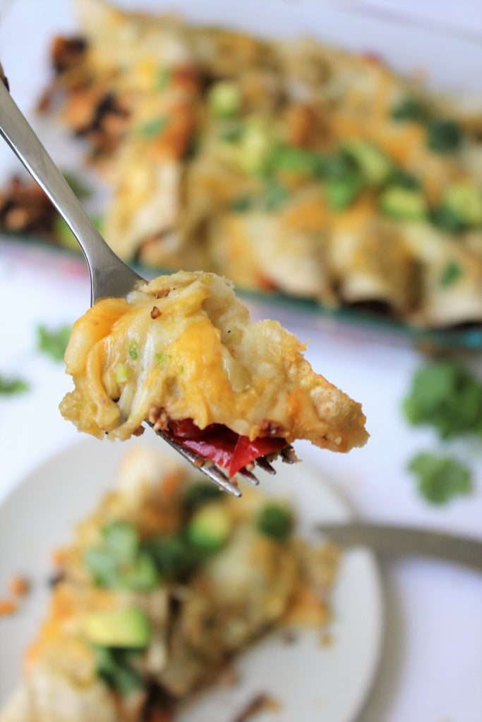 Close up bite of cheesy vegetarian enchilada